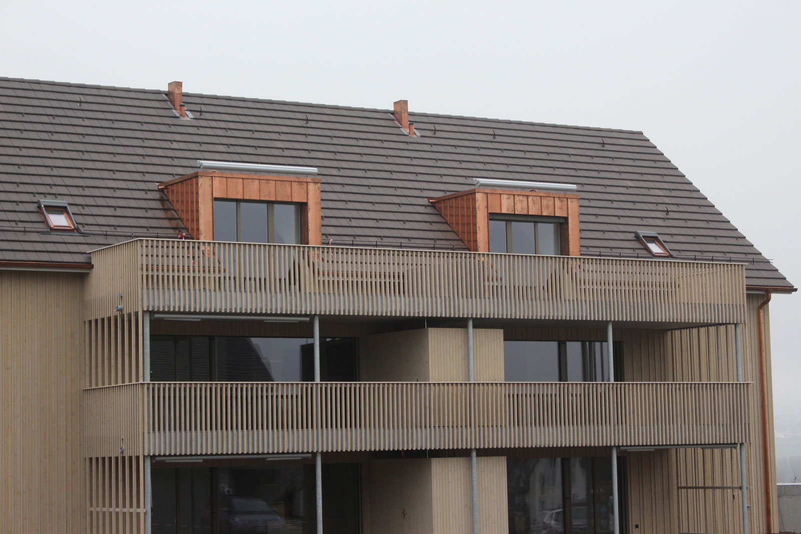 Mehrfamilienhaus mit zwei verkleideten Lukarnen